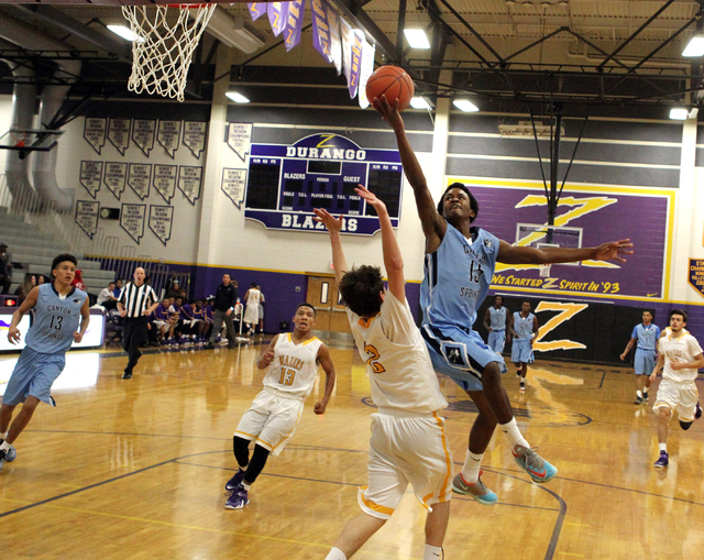 Canyon Springs guard Derrick Legardy (15) goes up for a shot over Durango guard Alex Tarkani ...