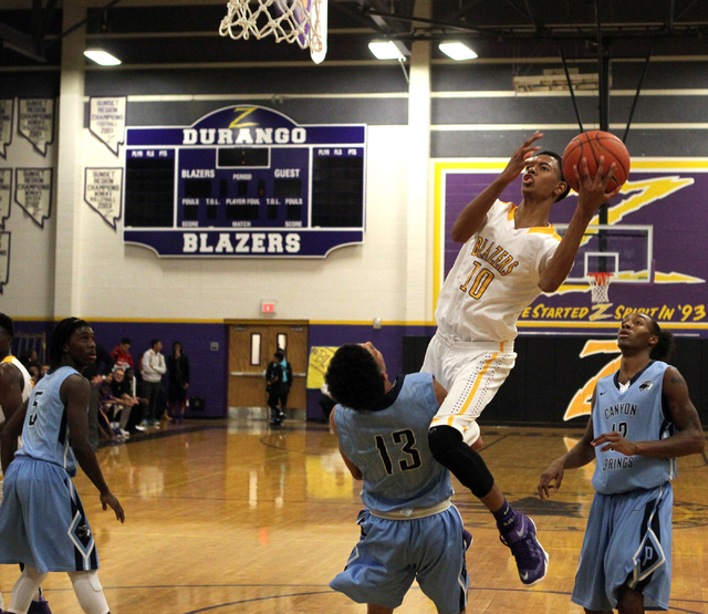 Durango forward Michael Diggins (10) is fouled by Canyon Springs guard Channel Banks (13) in ...