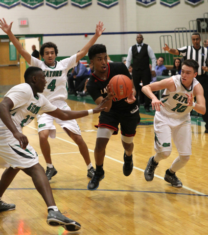 Las Vegas point guard Devon Colley (12) drives against Green Valley’s Romello Jones (2 ...