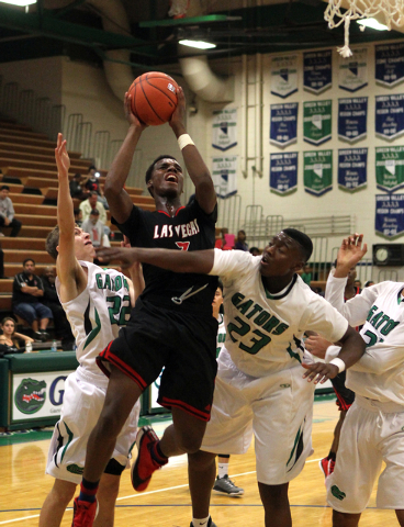 Las Vegas guard Tyshon Raybon (3) shoots between Green Valley shooting guard Dominick Ponton ...