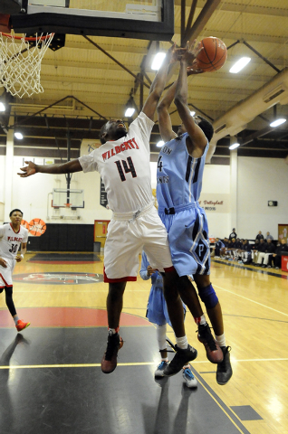 Las Vegas High guard Deshawn Weathers (14) blocks a shot attempt by Canyon Springs forward D ...