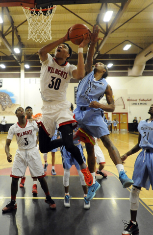 Las Vegas High forward Tyler Bey (30) attempts a layup as Canyon Springs forward Maurice Hun ...