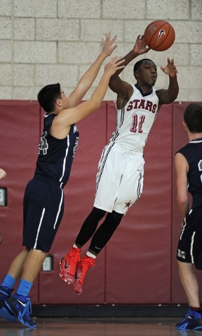 Agassi Prep guard Deishuan Booker (11) throws an inbound pass past The Meadows forward Micha ...