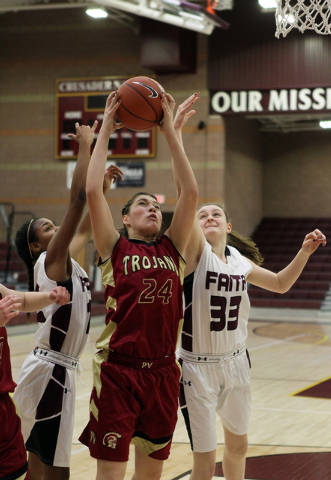 Pahrump’s Helen Vann (24) goes for a rebound between Faith Lutheran’s Haley Vins ...