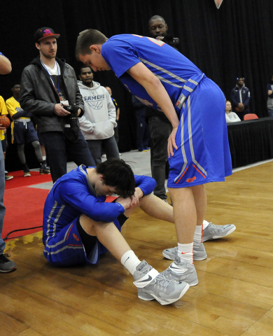 Bishop Gorman center Stephen Zimmerman, left, and Bishop Gorman guard Cole Michels, right, r ...