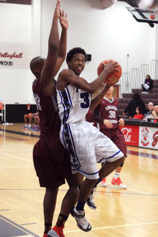 Basic forward Robert Sutton slips past Cimarron-Memorial center Terrell Walker during their ...