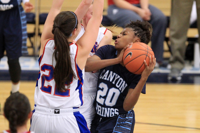 Canyon Springs guard Alexia Thrower runs into Reno’s McKain Murdock and Mallory McGwir ...