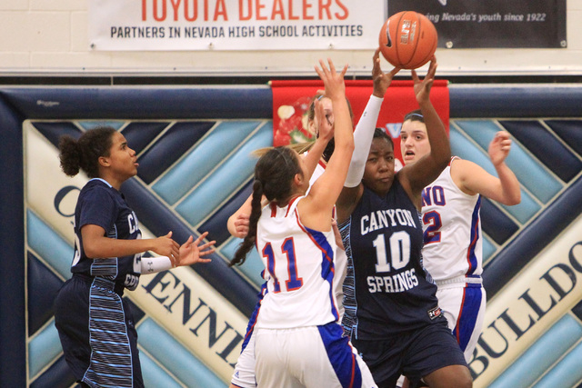 Canyon Springs forward Dre’una Edwards pulls down a rebound between Reno players Daran ...