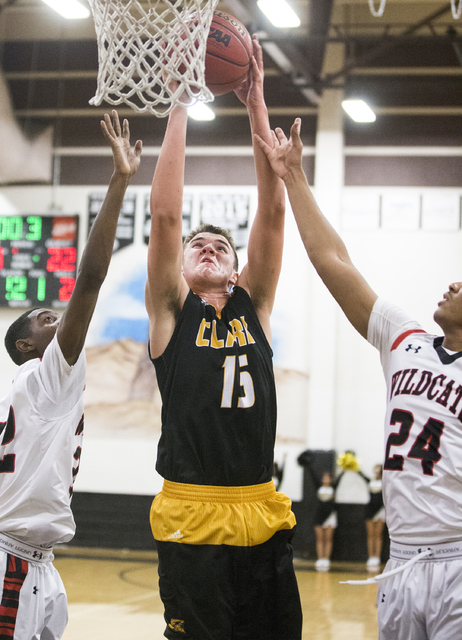 Clark’s James Bridges (15) grabs a rebound over Las Vegas’ Zach Matlock (24) and ...