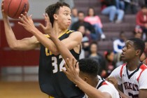 Clark’s Ian Alexander (32) fights for a loose ball with Las Vegas’ Zach Matlock ...