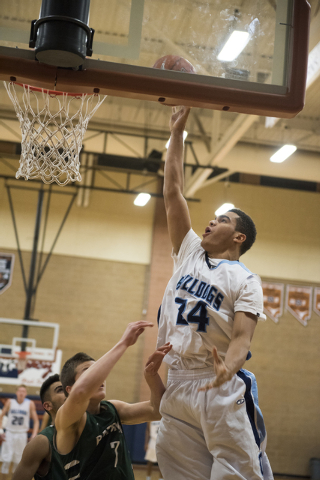 Centennial’s Jamaal Evans (34) goes up for a shot over Matt Keir (7) of Robert Bateman ...