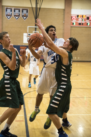 Centennial’s Marquise Buchanan (30) goes up for a shot over Nate Friesen (15) left, an ...