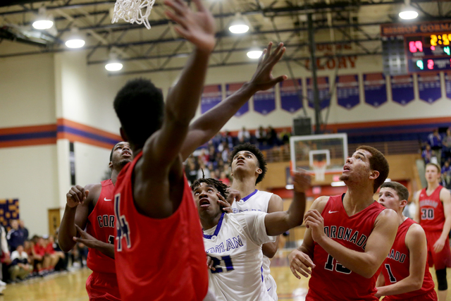 Both Bishop Gorman and Coronado teams wait to catch a rebound during a basketball game at Bi ...