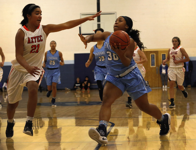 Centennial’s Tylise Taylor (30) drives towards the hoop against Aztec’s Myra M ...