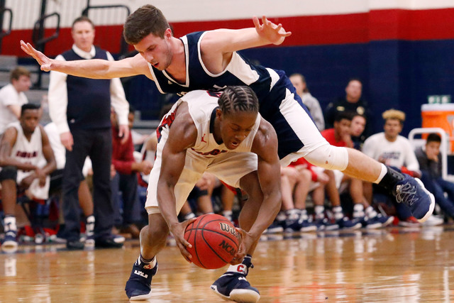 Foothill’s Mauricio Smith (4) hangs of the back of Coronado’s Nick Davis (3) aft ...