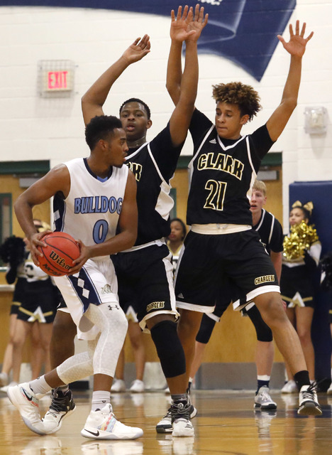 Centennial’s Troy Brown (0) is double teamed by Clark’s Jalen Hill (21) and Clar ...