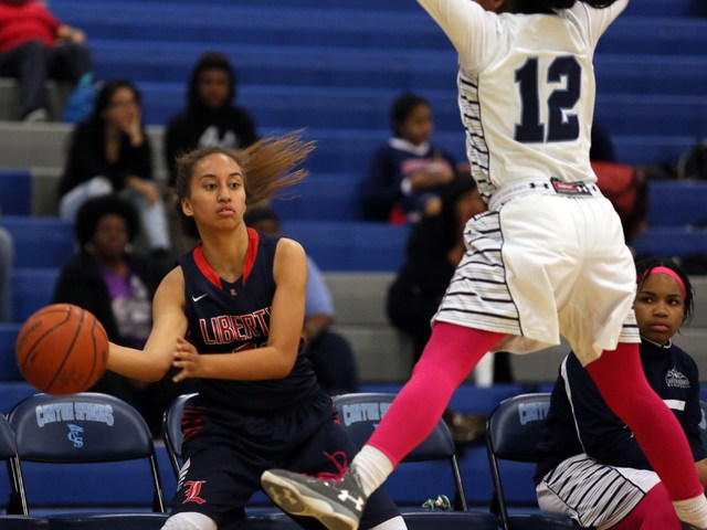 Liberty’s Kaily Kaimikaua, left, looks to pass around Canyon Springs’ LaKiya Yar ...