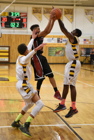 Desert Oasis guard Rodrick Moore, center, goes after the rebound against Bonanza’s Tra ...