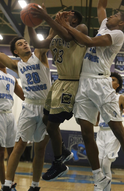 Cheyenne’s Dewayne Alexander (23) is fouled hard by Canyon Spring’s Joseph Haulc ...