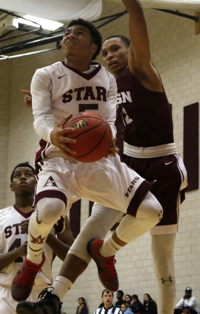 Agassi’s Allen Merritt (50) shoots a layup over Innovations International’s Just ...