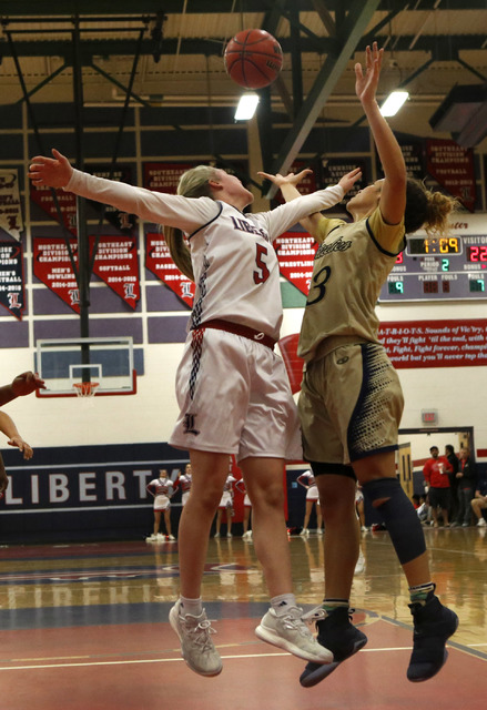 Liberty’s London Pavlica (5) and Spring Valley’s Essence Booker (3) jumps after ...