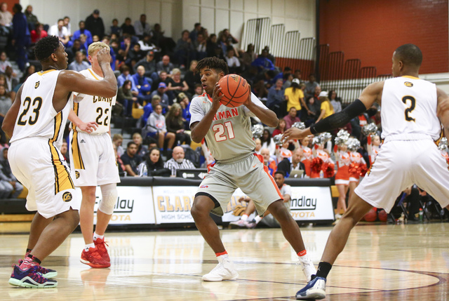 Bishop Gorman’s Christian Popoola (21) looks to get around Clark defense during a bask ...