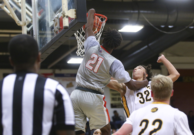 Bishop Gorman’s Christian Popoola (21) dunks the ball over Clark’s Ian Alexander ...