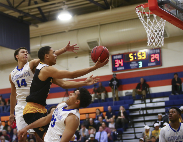 Clark forward Deshawn Wilson (5) goes up for a shot between Bishop Gorman forwards Saxton Ho ...