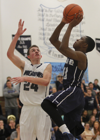 Agassi Prep’s Deishuan Booker (11) shoots over The Meadows’ Jake Epstein (24) ea ...