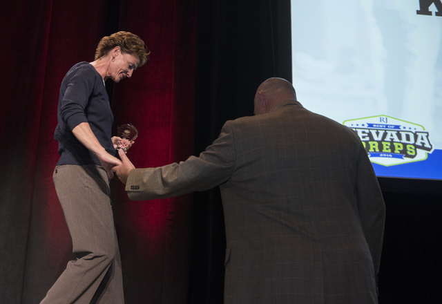 Centennial High School girls basketball coach Karen Weitz is escorted down the stage after w ...