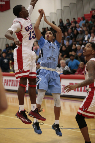 Canyon Springs senior Jordan Davis (1) shoots a jumper over Valley senior Nick Brannon (23) ...