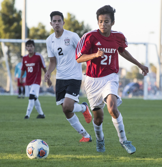 Sergio Ortiz (21), from Valley High School, battles for the ball against Isac Nolasco (2), f ...