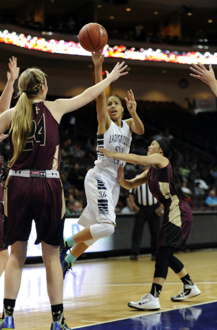 Spring Valley forward Kayla Harris attempts a shot as Faith Lutheran guard Madison Bocobo de ...