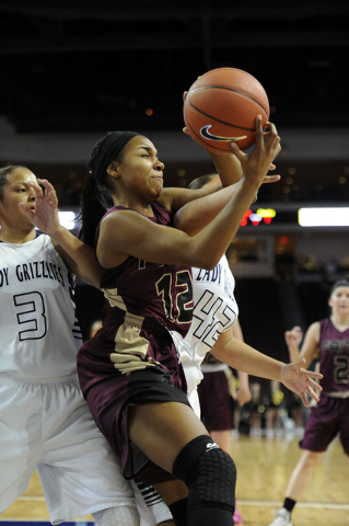 Faith Lutheran guard Haley Vinson (12) grabs a rebound in front of Spring Valley guards Esse ...