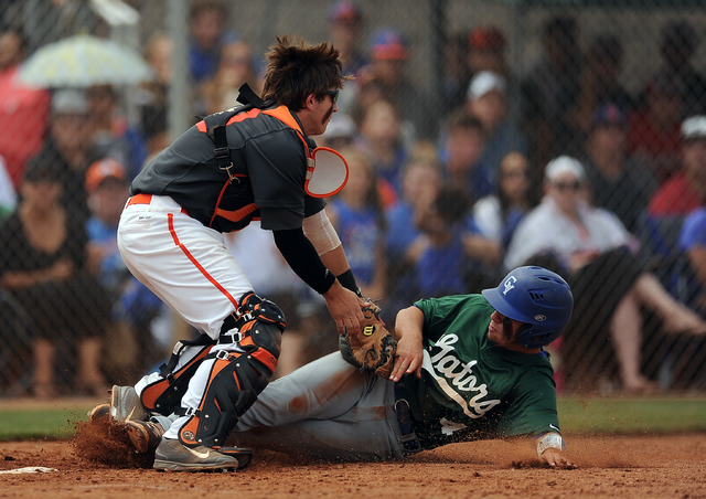 Bishop Gorman catcher Jordan Sadovia tags out Green Valley base runner A.J. Amelburu (4) at ...