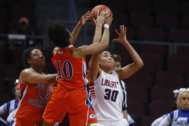 Bishop Gorman forward Alaysia Robinson and Liberty forward Paris Strawther fright for a rebo ...