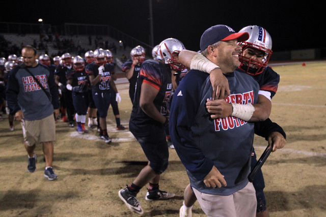 Liberty head coach Richard Muraco gets a hug from Josh Bernard Lee after the Patriots defeat ...