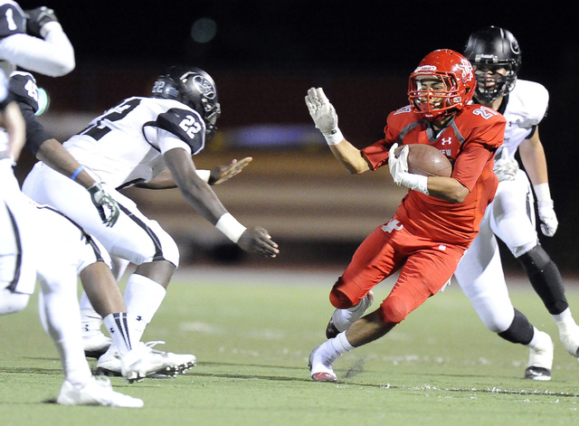 Arbor View center running back Charles Louch (21) looks for running room as Palo Verde lineb ...