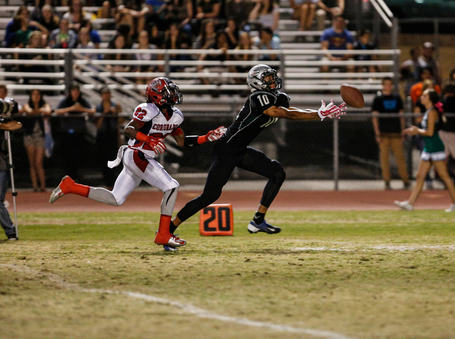 Green Valley junior Isaiah Macklin, right, reaches for a catch against Coronado junior defen ...