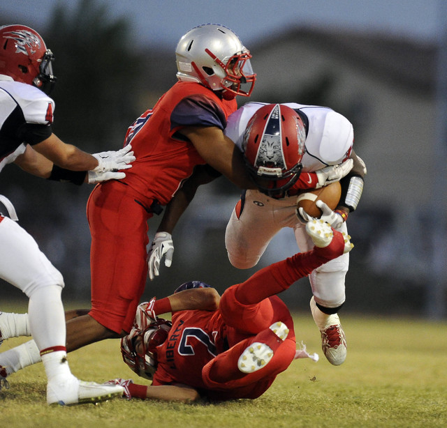 Liberty defensive end Rudy Bukassa, left, and defensive back Ethan Dedeaux (2) tackle Corona ...