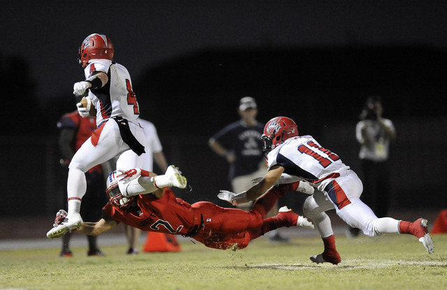 Liberty defensive back Ethan Dedeaux (2) tackles Coronado wide receiver Michael Simpson (4) ...