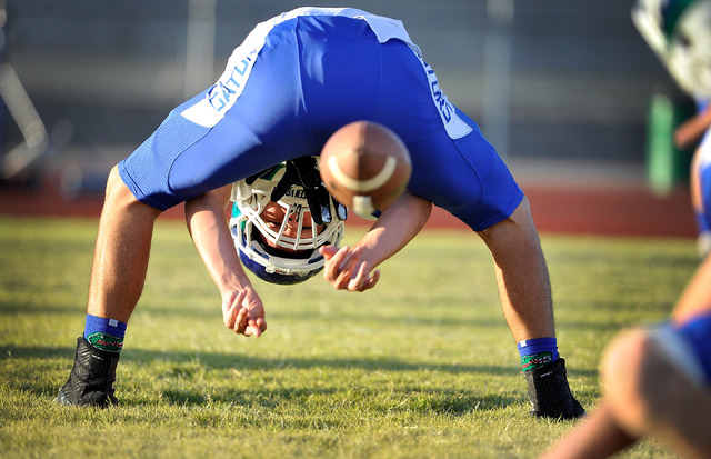 Green Valley’s Mason Elario snaps the ball to Ryan Becker, as the two warm up with the ...