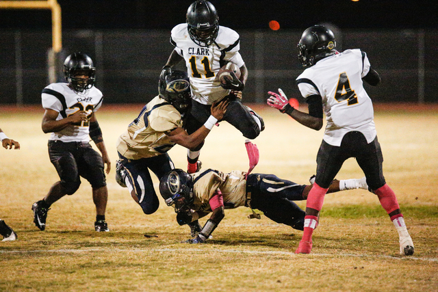 Cheyenne’s Noah Harker (11) attempts to avoid a tackle by a Clark player in the first ...