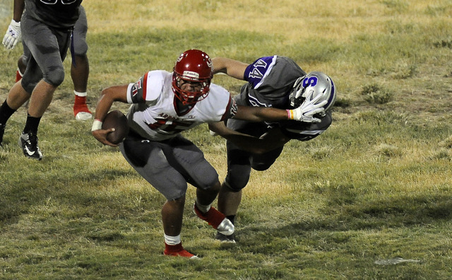 Arbor View quarterback Bryce Poster breaks the tackle of Silverado linebacker Garrett Chanic ...