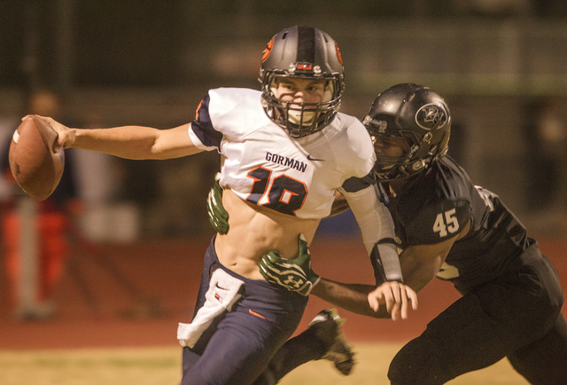 Bishop Gorman quarterback Tate Martell, left, slips the grasp of Palo Verde linebacker Dalla ...