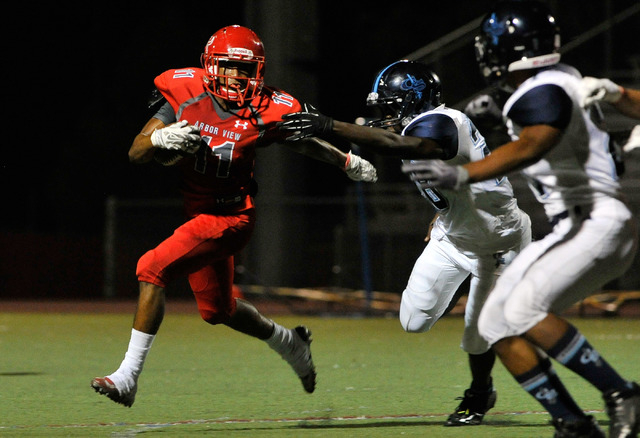 Arbor View’s Maurice Harvey (11) runs from Canyon Springs defenders during the first h ...