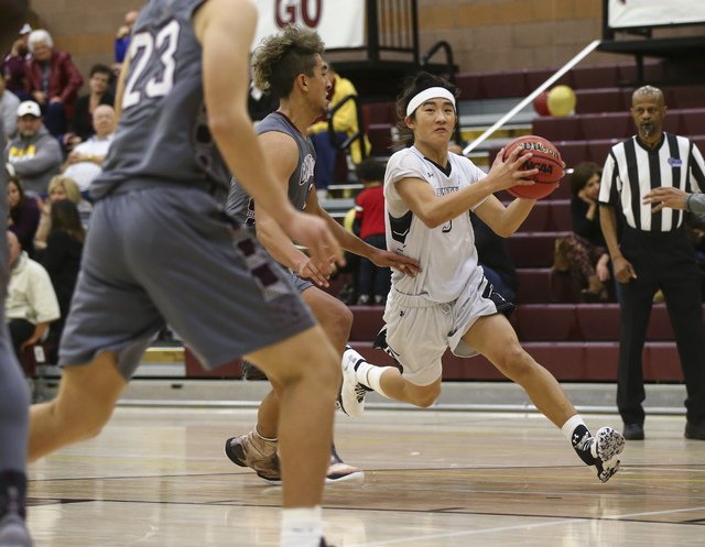 Faith Lutheran Josh Hong (3) drives the ball against Cimarron-Memorial during a basketball g ...