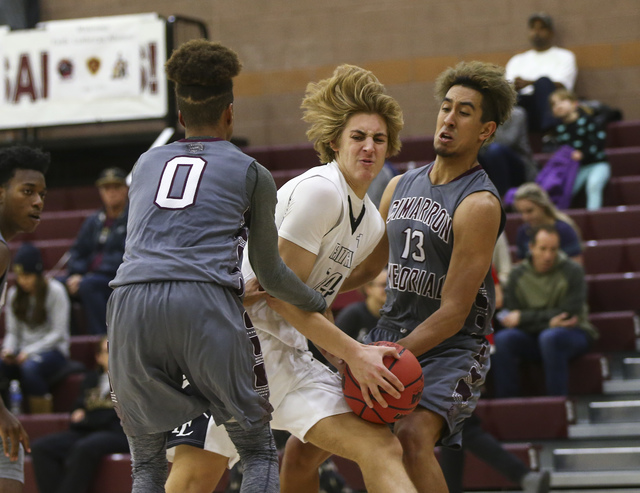 Cimarron-Memorial’s Keiron Hatchett (0) and Kamakana Winquist (13) defend Faith Luther ...