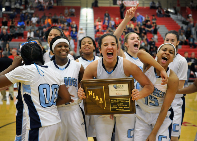 Centennial’s Karina Brandon, center, holds the championship trophy after the Bulldogs ...