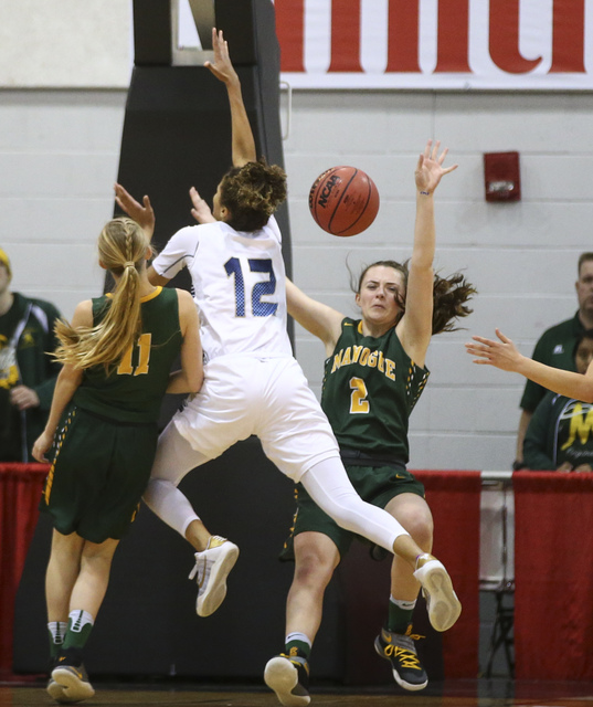 Foothill’s Rae Burrell (12) collides with Bishop Manogue forward Maddie Camacho (2) du ...